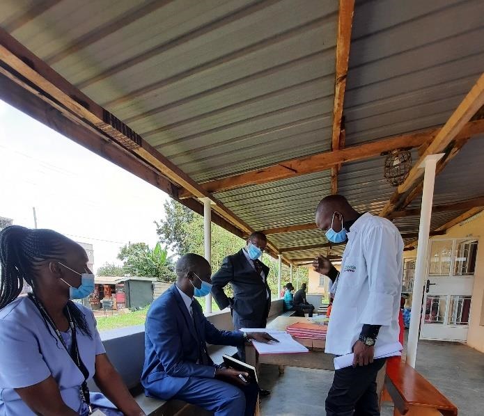 Dr Mutungi (seated) reviewing registers to check for data on NCD screening. 