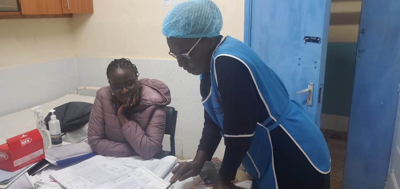 During LSTM post-training follow up site visit, Margaret shared the Antenatal register, showing that mothers at Mois Bridge health center in Uasin Gishu are attending 7 or more ANC contacts during pregnancy./credit: LSTM