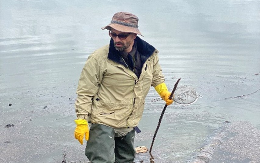 Prof Stothard searching for snails in the dam