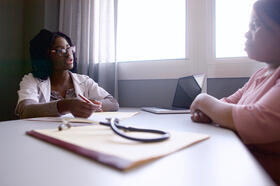 Young Female Doctor discussing a medical report with a senior female patient