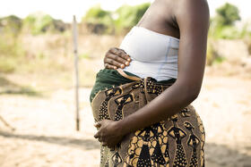 A pregnant African woman holding her stomach