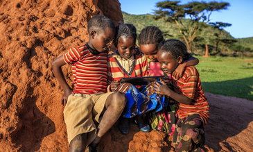 Little African children using digital tablet in the village in Southern Ethiopia, Africa. /Credit:hadynyah