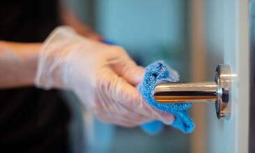 Door handle being cleaned with disinfectant