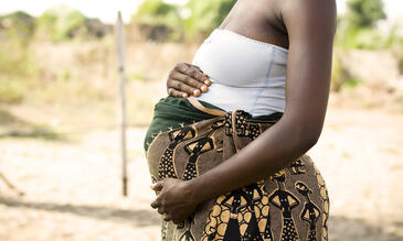 A pregnant African woman holding her stomach