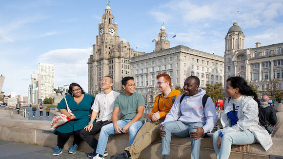 Photo of a group of LSTM students infront of the Liver Building in Liverpool