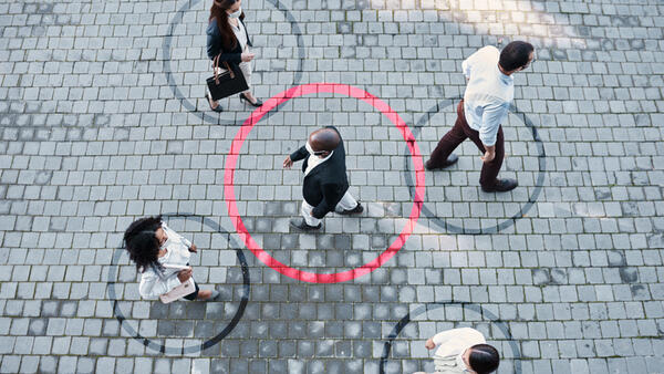 Shot of a group of people wearing masks in the city with circles around them indicating Covid-19 tracing and transmission