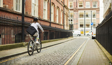 woman cycling through the city centre
