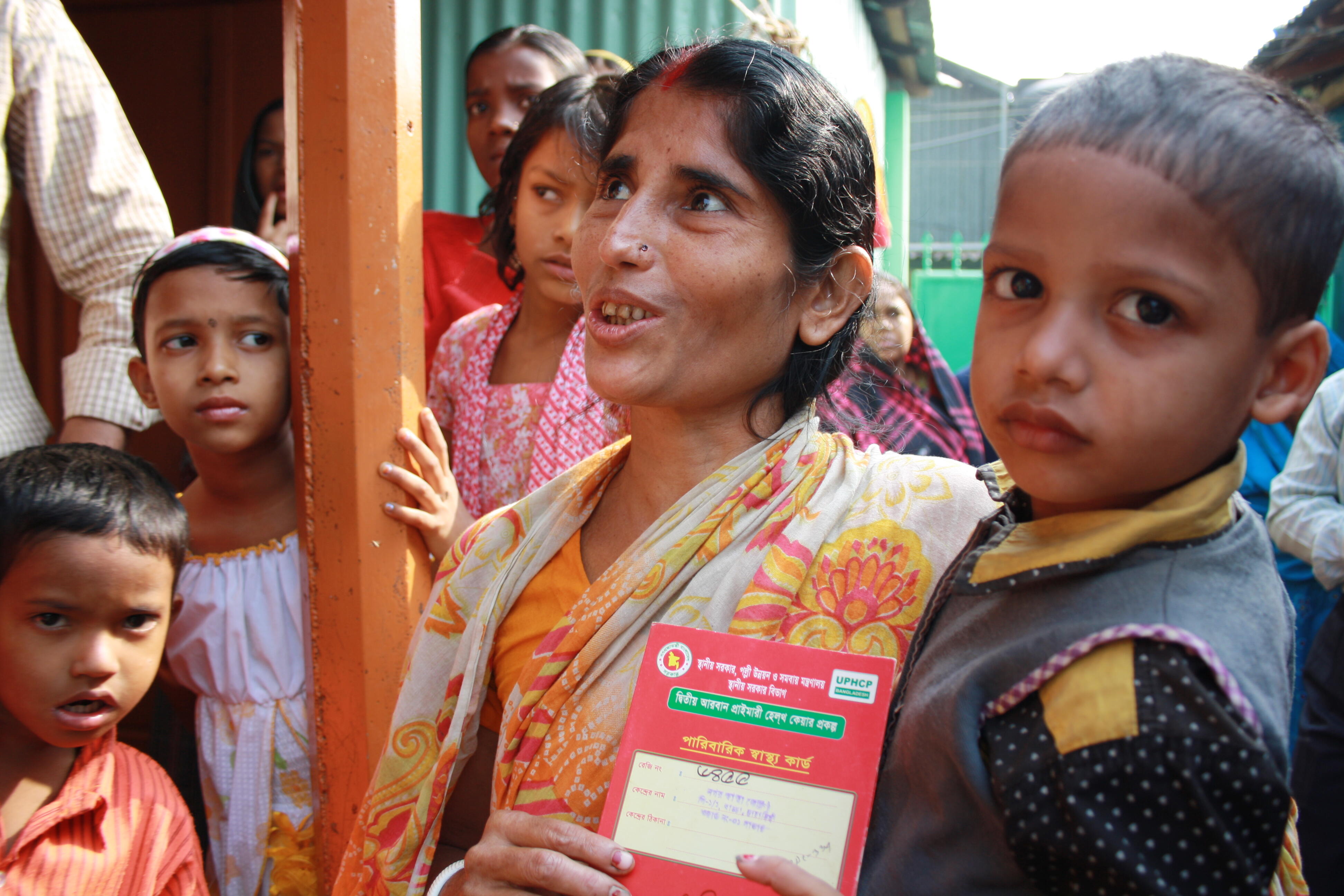A woman with her 'red health card', which allows her to access government health services in the Korail slum, Dhaka, Bangladesh. Photo: Lucy Milmo/DFID