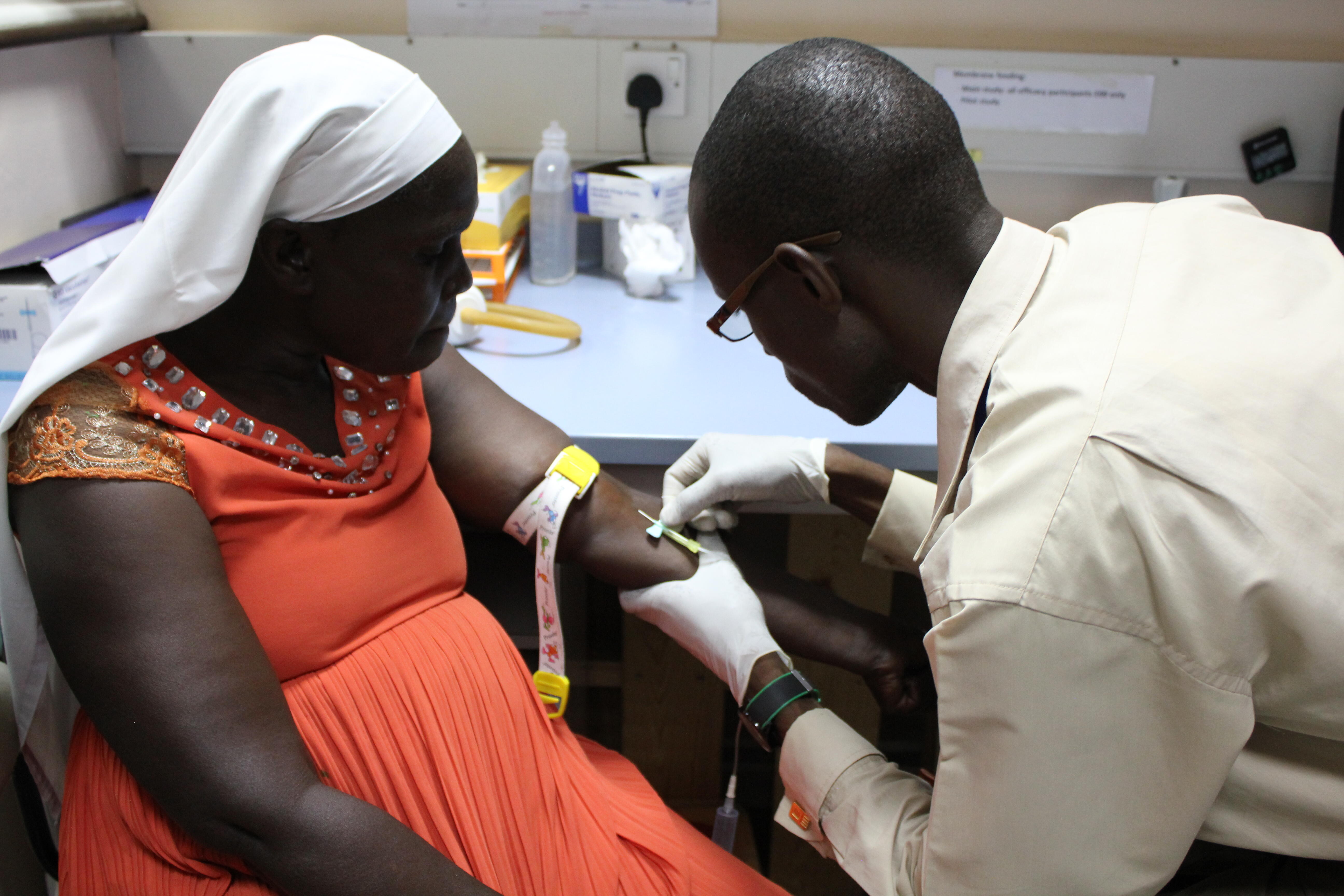 Wycliffe Onyango, clinical officer, draws blood for mosquito feeding from one of the study patients [patient gave written consent to publish photo]