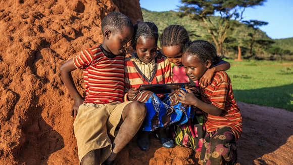 Little African children using digital tablet in the village in Southern Ethiopia, Africa. /Credit:hadynyah