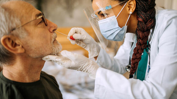 Clinician taking nasal swab from patient