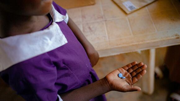 Image of child's hand holding a medical pill