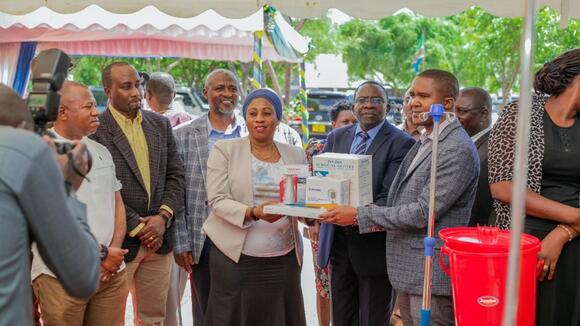 Hon. Ummy Mwalimu (MP) and Minister of Health in Tanzania handing over medical equipment to the heads of the relevant Councils on behalf of each facility. Photo Credit: UDOM