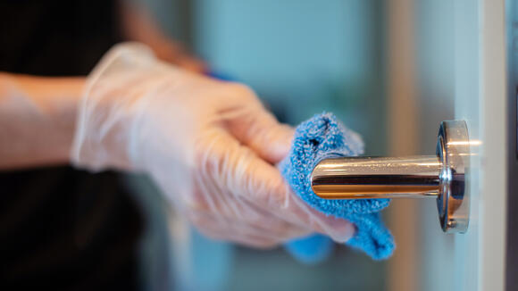 Door handle being cleaned with disinfectant