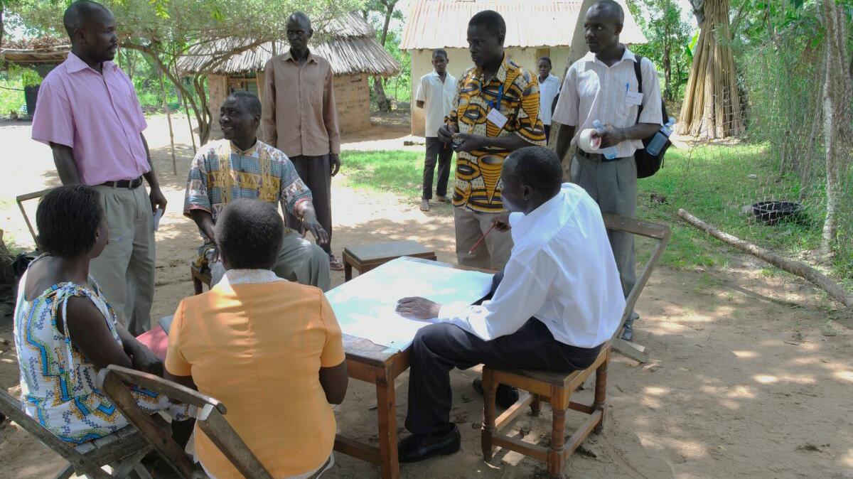 A group of people sitting around a table looking at a map.